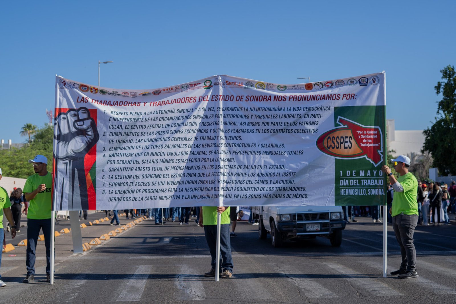 Contingente sosteniendo la lona principal con las 8 demandas laborales durante el desfile del Día del Trabajo en Hermosillo.