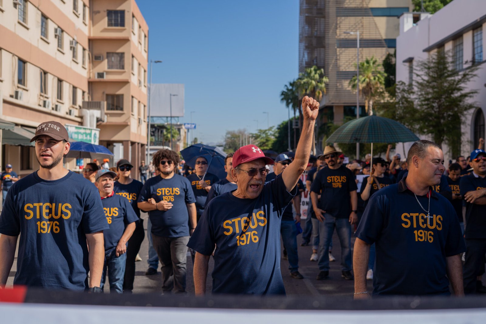 Contingente sosteniendo la lona principal con las 8 demandas laborales durante el desfile del Día del Trabajo en Hermosillo.