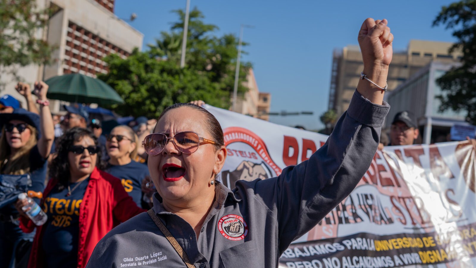 Contingente sosteniendo la lona principal con las 8 demandas laborales durante el desfile del Día del Trabajo en Hermosillo.