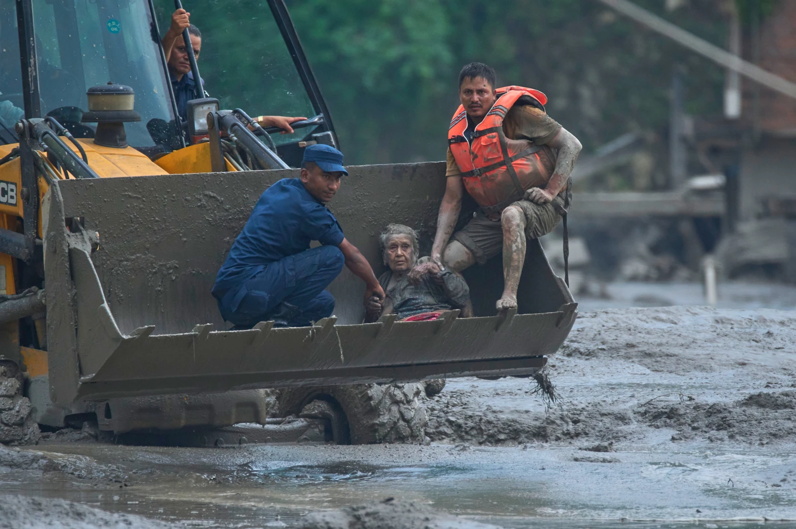 Rescatistas y sobrevivientes en las zonas devastadas por las inundaciones repentinas en la frontera entre Nepal y China.